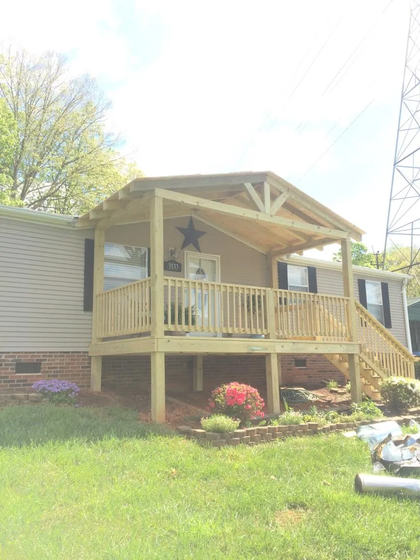 New gabled porch roof and deck railing added to a ranch home in Milton